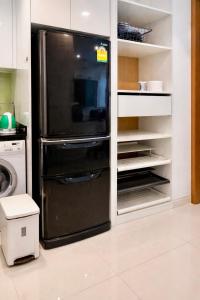 a kitchen with a black refrigerator in a kitchen at NexStay Bangkok Appartment in Bangkok