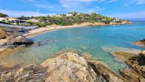 a view of a beach with rocks in the water at Studio Serenity - Clim - WIFI - Parking - Piscine - Front de mer - Proche commerces et centre ville in Fréjus