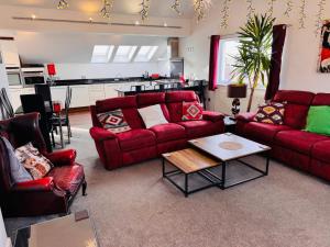 a living room with red couches and a table at The Shelbourne in Southport