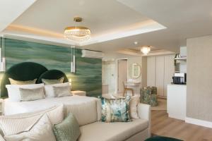 a bedroom with a white bed and a couch at Views Boutique Hotel & Spa in Wilderness