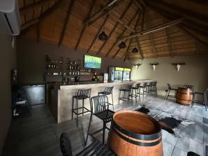a bar with a bunch of chairs and a table at Moyo Safari Lodge in Alldays