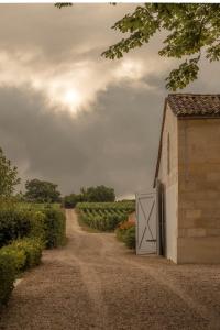a barn with a white door on a dirt road at Château Fonroque - Camomille in Saint-Émilion