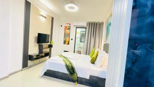 a bedroom with a white bed and a mirror at HS Miracle View in Hulhumale