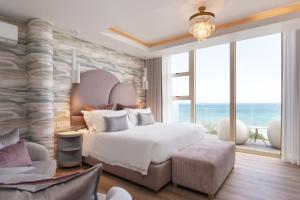 a bedroom with a large bed and a large window at Views Boutique Hotel & Spa in Wilderness