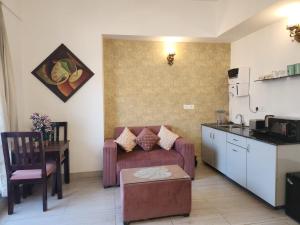 a living room with a couch and a kitchen at Tranquil Homes in Noida