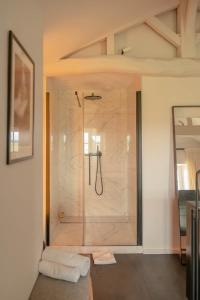 a bathroom with a shower with a glass door at Château Fonroque La Suite in Saint-Émilion