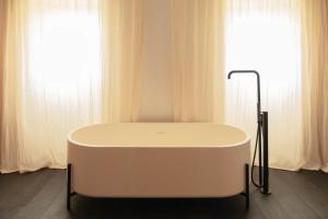 a bath tub sitting in front of two windows at Château Fonroque La Suite in Saint-Émilion