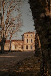 a large white house with trees in front of it at Château Fonroque La Suite in Saint-Émilion
