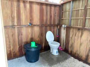 a bathroom with a toilet and a trash can at Isiie Homestay in Merpati