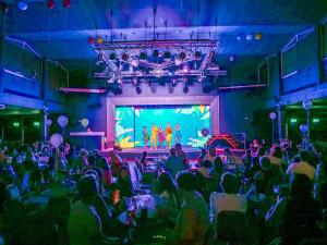 a crowd of people sitting in a room with a stage at Beverley Park in Goodrington