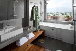 a bathroom with a sink and a tub and a window at Coco-Mat Hotel Nafsika in Athens +59 photos