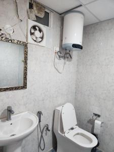 a bathroom with a white toilet and a sink at Tranquil Homes in Noida +12 photos