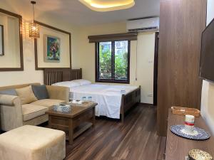 a living room with a bed and a couch at An Thuong House - Hoan Kiem, Hanoi Center in Hanoi