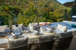 a table with plates and glasses on top of a deck at Villa Slowave in Balatonalmádi