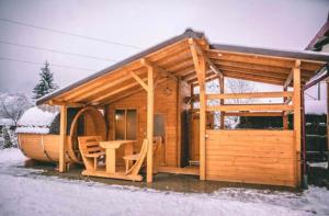 a small wooden cabin with a table in the snow at Paunasul Codrilor in Câmpulung Moldovenesc