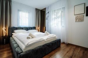 a bedroom with a large bed with white sheets at Villa Slowave in Balatonalmádi +61 photos