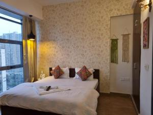 a bedroom with a white bed with a window at Tranquil Homes in Noida