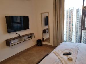 a hotel room with a tv and a bed and a mirror at Tranquil Homes in Noida