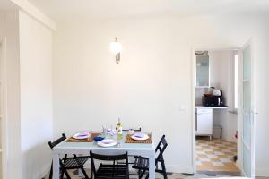 a white dining room with a table and chairs at InnPisaRentals2- Casa dei Cavalieri in Pisa