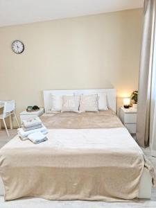 a bedroom with a large bed with a clock on the wall at Dunes Trail 4 in Melnragė