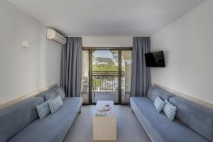 a living room with a blue couch and a tv at Apartamentos Casa Vida in Santa Ponsa