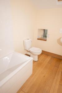 a white bathroom with a toilet and a bath tub at Longère de charme en pleine nature in Chillac +8 photos
