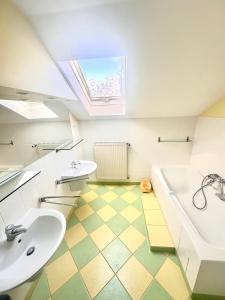 a bathroom with two sinks and a tub and a window at Asetech Sandra in Pasym