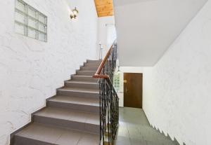 a staircase in a house with white walls and a wooden door at Asetech Sandra in Pasym