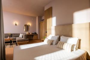 a bedroom with a bed and a living room at Petra Nera Skiathos, Philian Hotels & Resorts in Agia Paraskevi