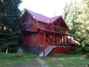a wooden house with a porch and a balcony at Casa Arion in Arieşeni