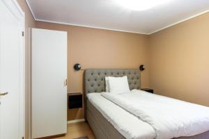 a small bedroom with a bed with white sheets at Simloc Hotel Öberget in Arjeplog