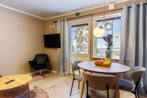 a living room with a table and chairs and a window at Simloc Hotel Öberget in Arjeplog