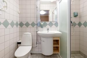 a white bathroom with a toilet and a sink at Simloc Hotel Öberget in Arjeplog +5 photos