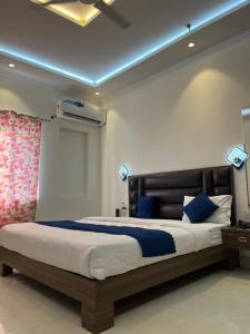 a bedroom with a large bed with blue lighting at Hotel Ashok Palace in Agra