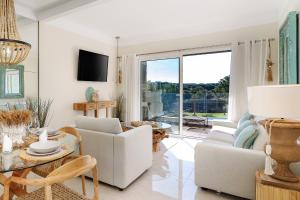a living room with white furniture and a large window at Apartment Belharucas in Albufeira