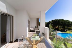 a balcony with a table and chairs and a pool at Apartment Belharucas in Albufeira