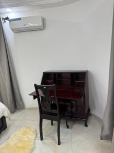 a piano sitting in a room with a chair at Home away from Home in Komé