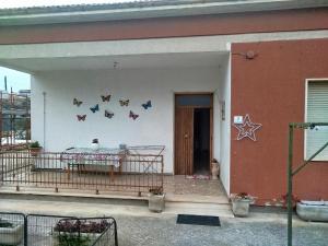 a house with a porch with a table and butterflies on the wall at Stella Bianca in Giulianova