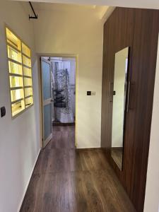 an empty hallway with a door and a mirror at Home away from Home in Komé