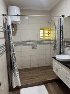 a bathroom with a sink and a shower at Home away from Home in Komé