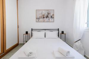 a bedroom with a white bed with white pillows at CorfuLevante Sea View in Barbati