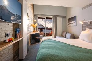 a hotel room with a bed and a living room at Hôtel Le Levanna by Les Etincelles in Tignes +70 photos