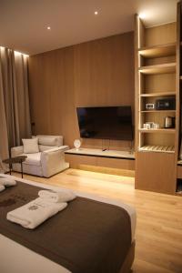 a room with a bed and a flat screen tv at Terra Boutique Hotel in Tirana