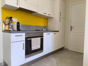 a kitchen with white cabinets and a stove top oven at HOSTEL MEYERBEER - Rooms and Apartments in Nice