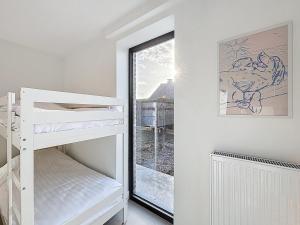 a white bedroom with a bunk bed and a window at Villa Pomone - Sint-Idesbald in Koksijde