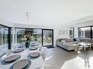 a dining room with a table and chairs and a couch at Villa Pomone - Sint-Idesbald in Koksijde