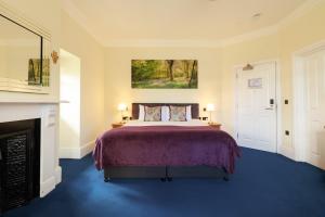 a bedroom with a bed and a fireplace at Northgate House in Buckfastleigh