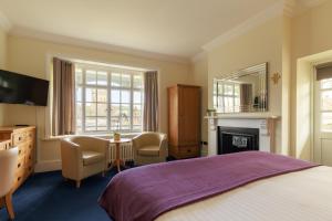 a bedroom with a bed and a desk and a fireplace at Northgate House in Buckfastleigh
