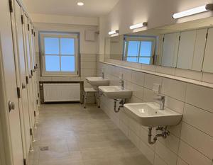 a bathroom with two sinks and two mirrors at Alpen-Schlaffass in Grainau