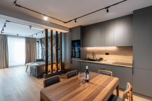 eine Küche und ein Esszimmer mit einem Holztisch und Stühlen in der Unterkunft Sky Nest Chalets in Buşteni